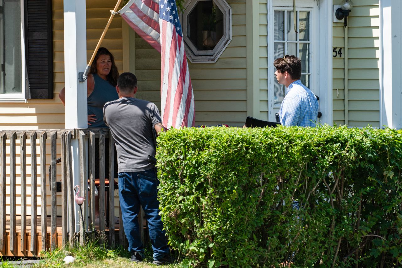 FBI investigators speak to a resident today as they work near the scene of an ICE-involved shooting in Biddeford, Maine.