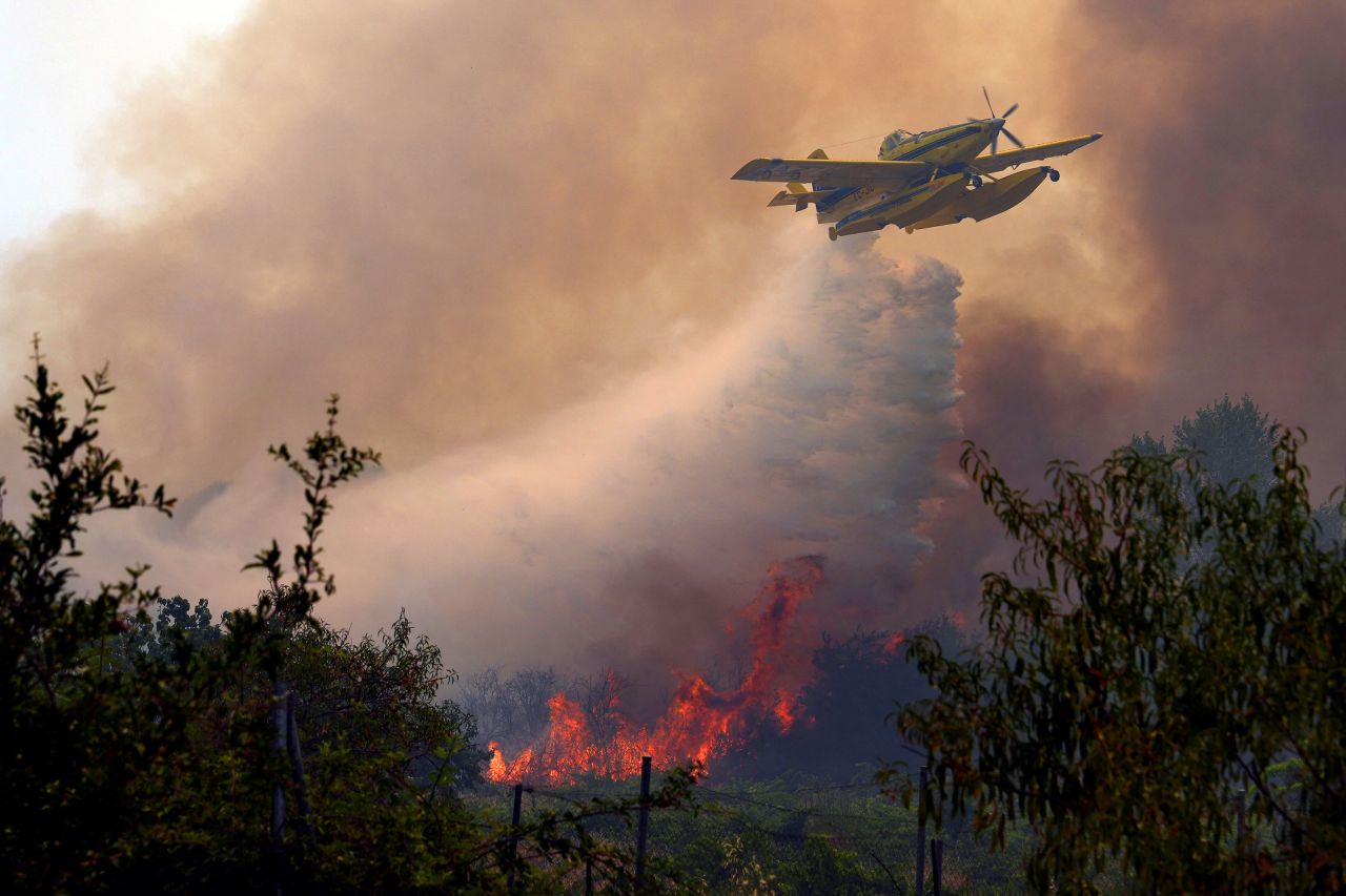 An aircraft dumps water over a wildfire burning near San Martín de Valdeiglesias, Spain.