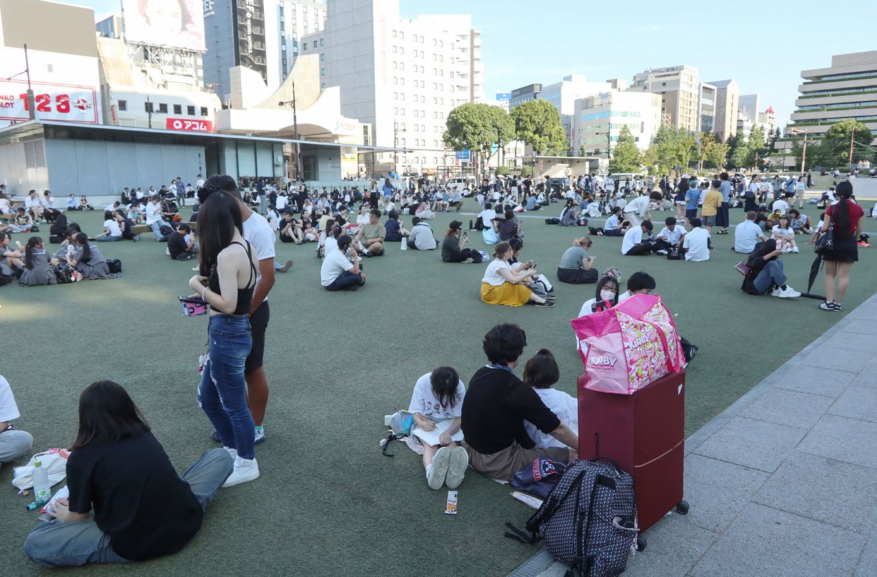 People wait in a park after evacuating buildings following an earthquake in Kumamoto City.