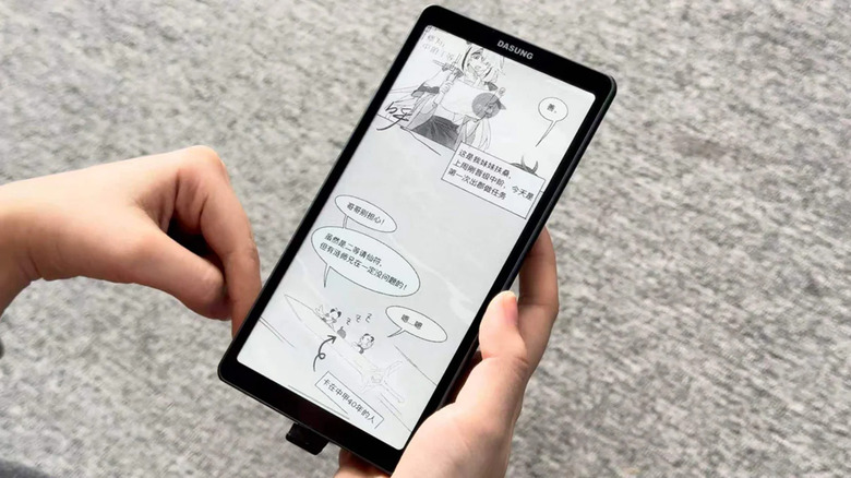 A person holding a Dasung 6.7 inch E-Ink display with a comic page open