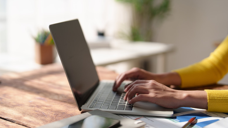 A person typing on a laptop computer