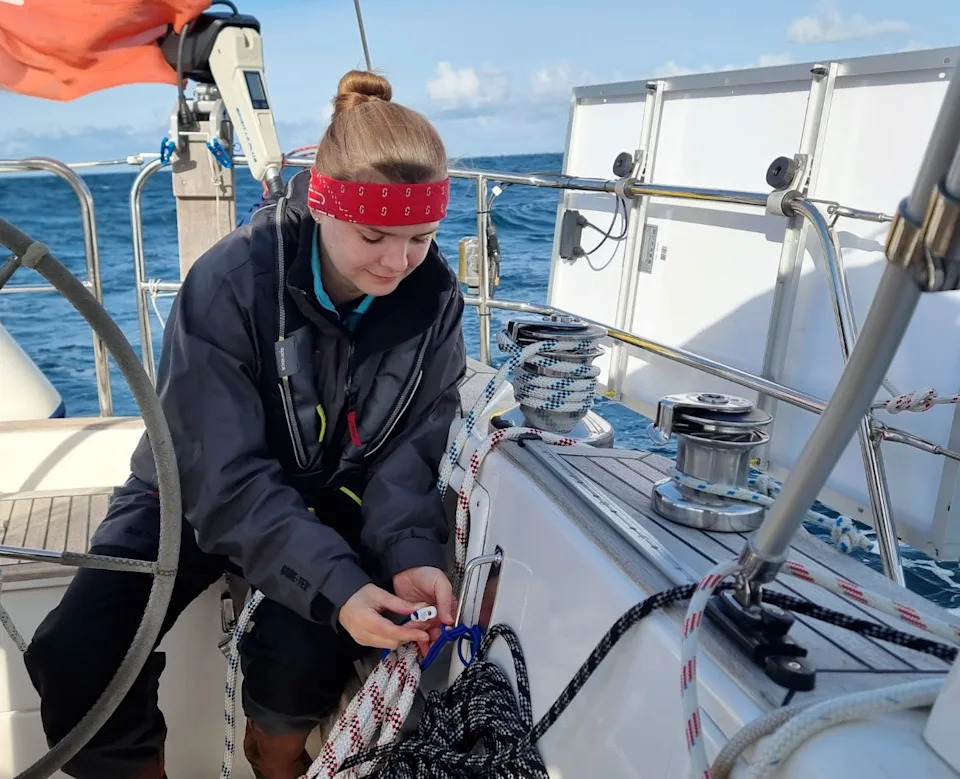 The writer wearing a bandana and using ropes to dock her boat.