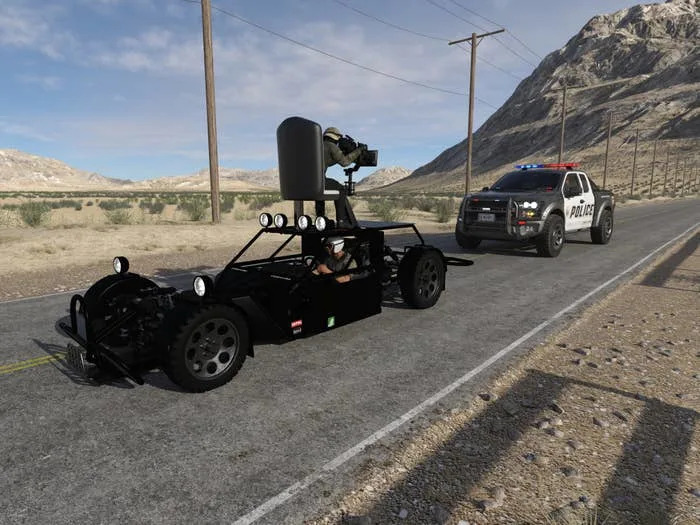 A police car pulls over a minimalist, black camera vehicle on a desert road with mountains in the background