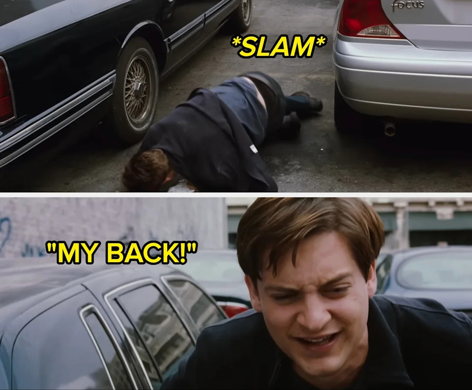 Person in a suit on the ground between two parked cars, appearing to look for something under the vehicles