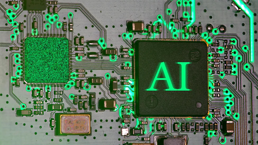 A close-up image shows a computer chip labeled "AI" connected to a circuit board illuminated with green light. Photo: Immo Wegmann / Unsplash