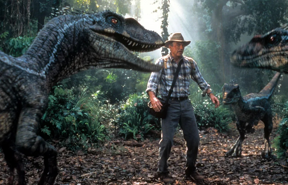 Sam Neill is confronted by three dinosaurs in a scene from the film Jurassic Park III.
