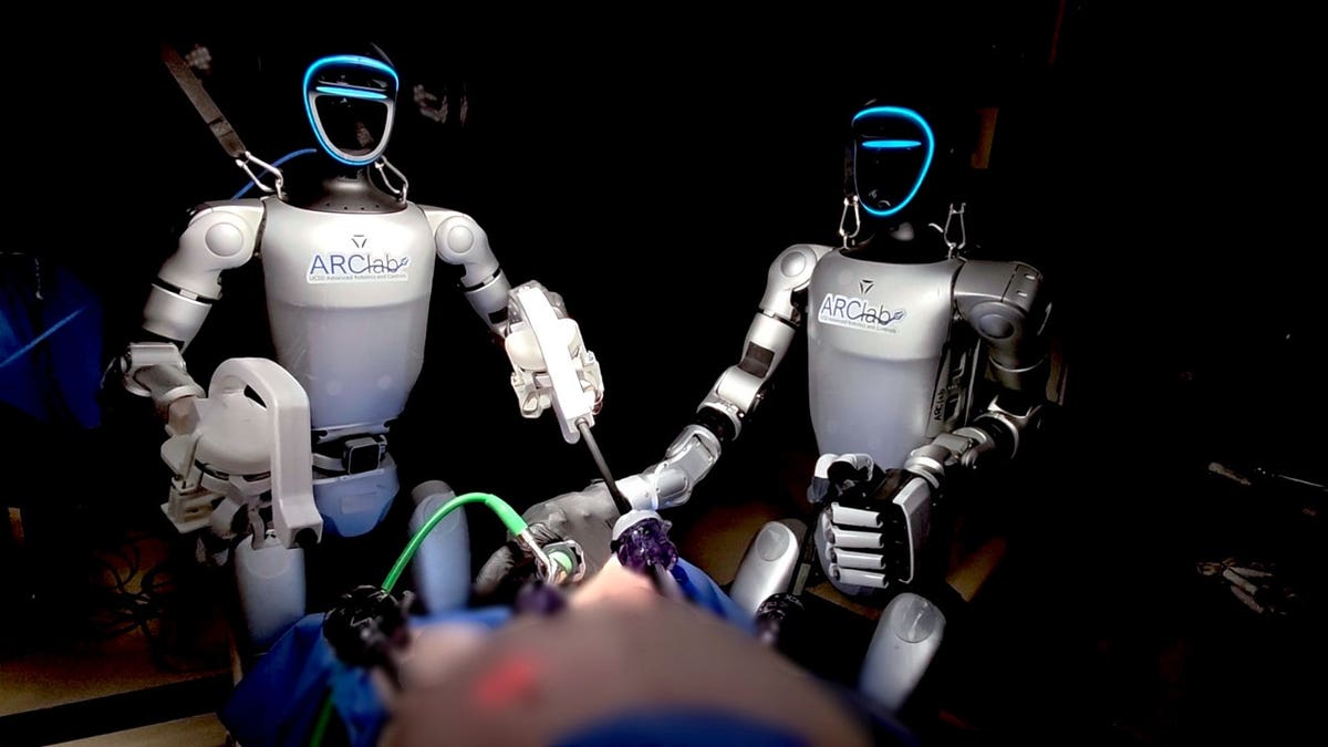 Two humanoid robots conduct a surgery.