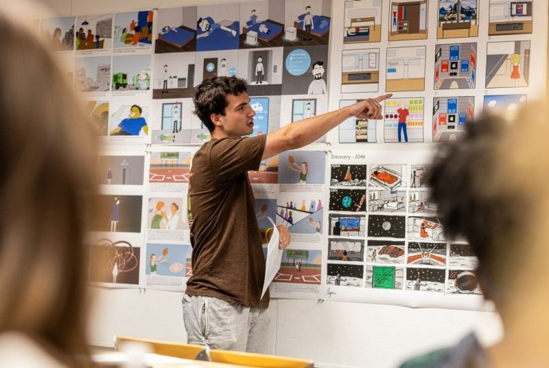 A student presents a storyboard illustrating a day in the life of a person living in a future world imagined through speculative design.