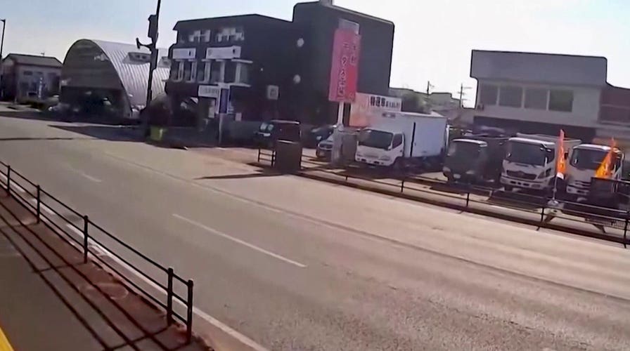 Surveillance video shows trucks shaking during Japan earthquake