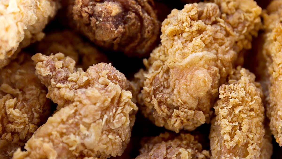 Pieces of KFC fried chicken are shown in a close-up image.