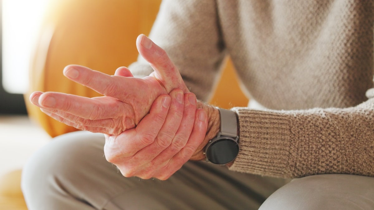 Man rubbing hand - Parkinson's symptom