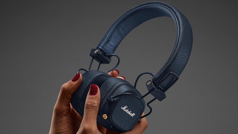 A person holding the Marshall Major V wireless headphones in their hands.