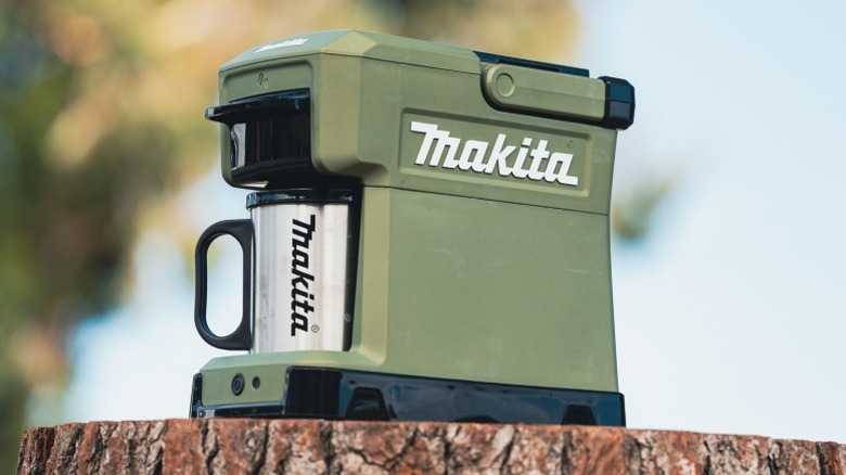 Makita Outdoor Adventure 18V LXT Coffee Maker on a tree stump