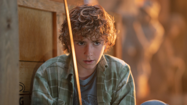 Walker Scovell as Percy Jackson sitting in the sunlight in a publicity still for Percy Jackson & the Olympians Season 1 Episode 3