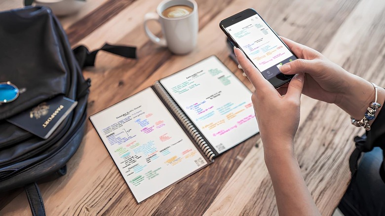 Woman holding a phone over a Rockebook smart notebook