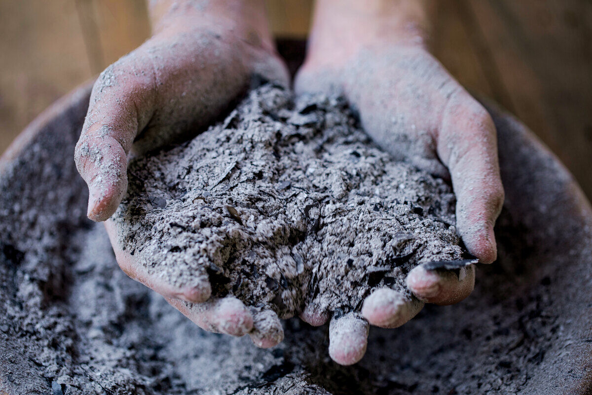 Cupped%20hands%20holding%20a%20pile%20of%20gray%2Dcolored%20coal%20ash%2E