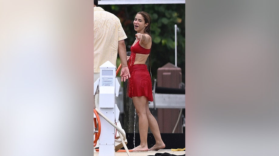 Shakira talking to someone and pointing while in a red bikini in Miami, Florida.
