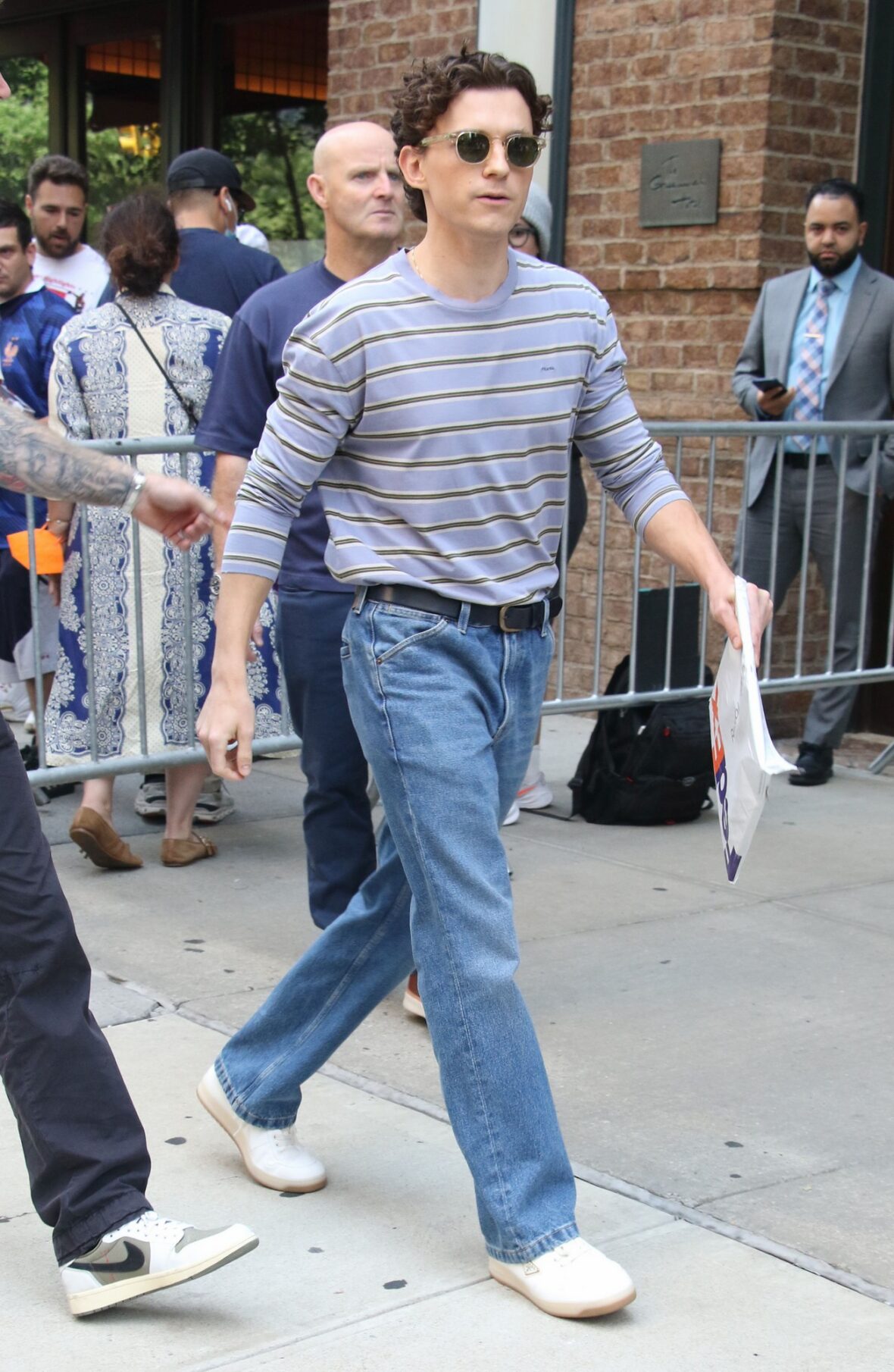 Tom Holland in a stripe long-sleeve top and jeans.