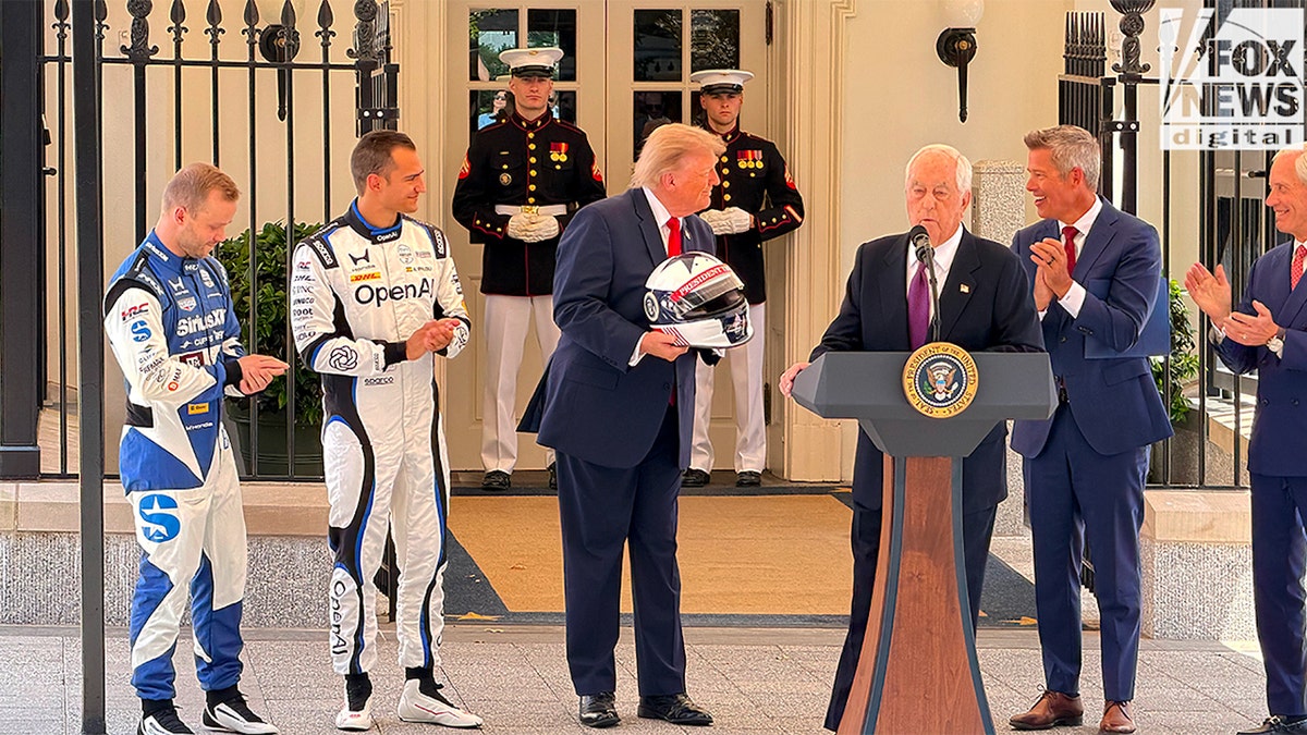 Trump smiling with INDYCAR helmet at Duffy at Grand Prix press conference