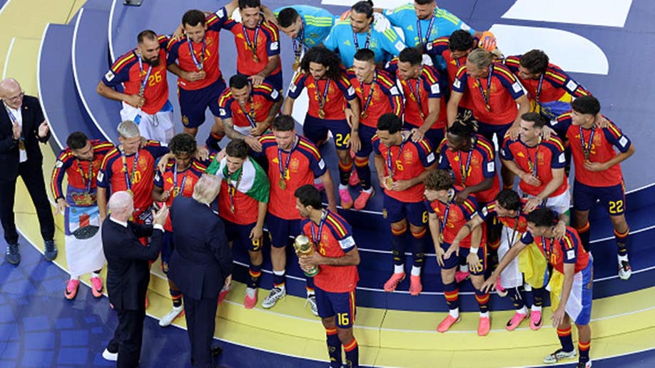 Rodri holds the FIFA World Cup Winner’s Trophy with Gianni Infantino and Donald Trump standing beside him.