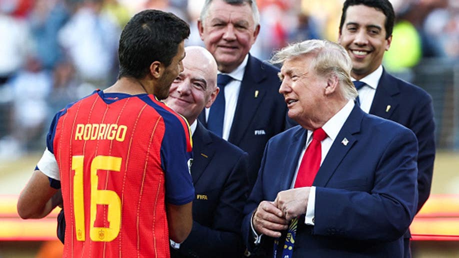 Rodri, Gianni Infantino and Donald Trump talk during an award ceremony.
