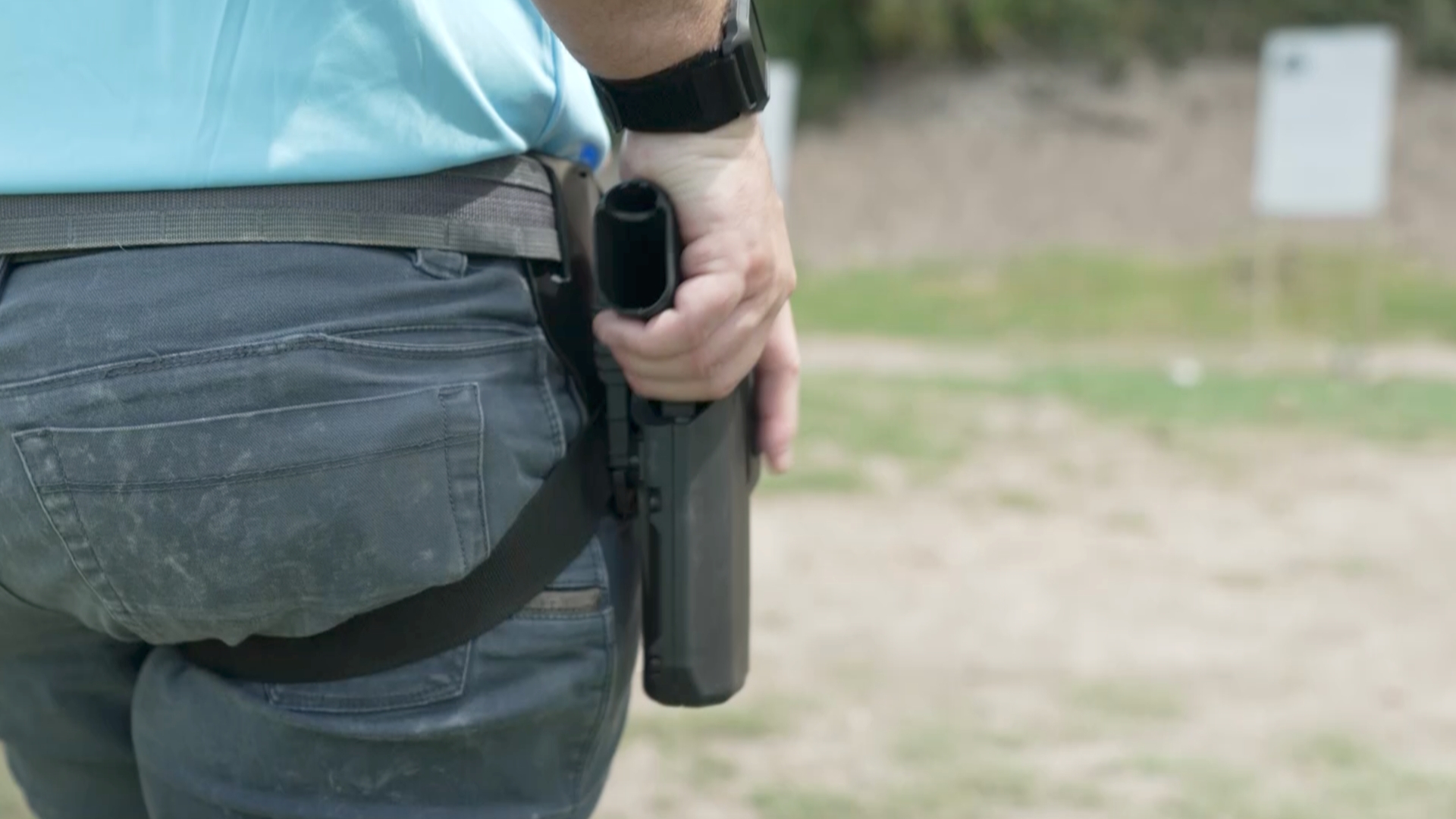 Daniel Jakobsson rests his hand on his holstered gun.