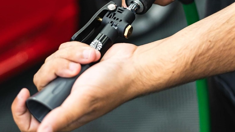 A person putting the Ultra Air Blaster Mini on the end of a nozzle