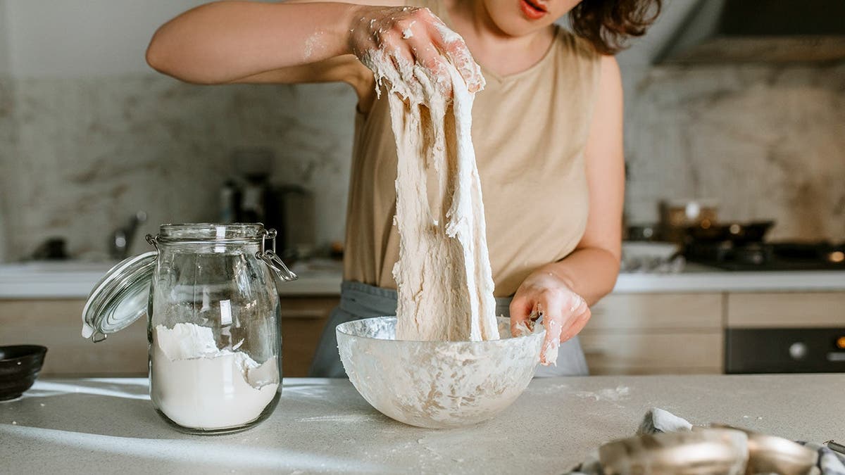 A woman makes bread at home.