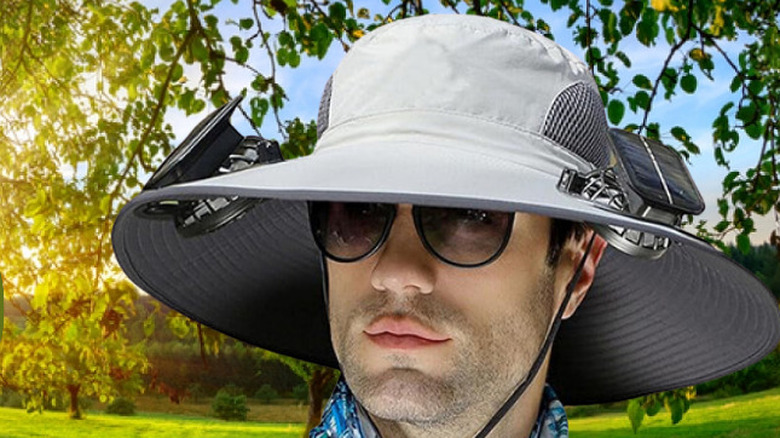 A person wearing the Xakava sun hat with solar fans outdoors.