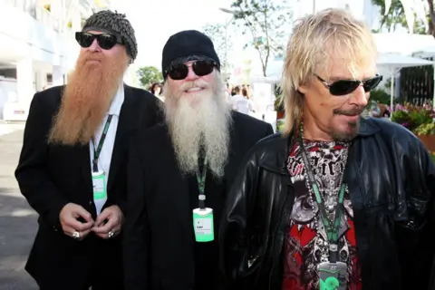 Getty Images ZZ Top lead vocalist Billy Gibbons, bassist Dusty Hill and drummer Frank Beard sport lengthy beards and sunglasses as they walk outdoors at the Formula One World Championship in Singapore on 24 September 2009.