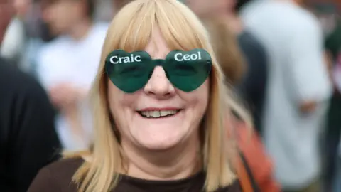 PA Media A woman with green heart glasses and blonde hair.