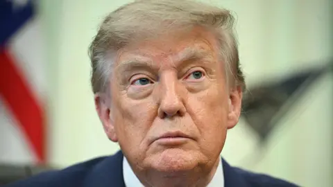 Getty Images US President Donald Trump looks on before signing an executive order calling for more research and flexibility on vaccines, in the Oval Office of the White House in Washington, DC, on August 10, 2026.