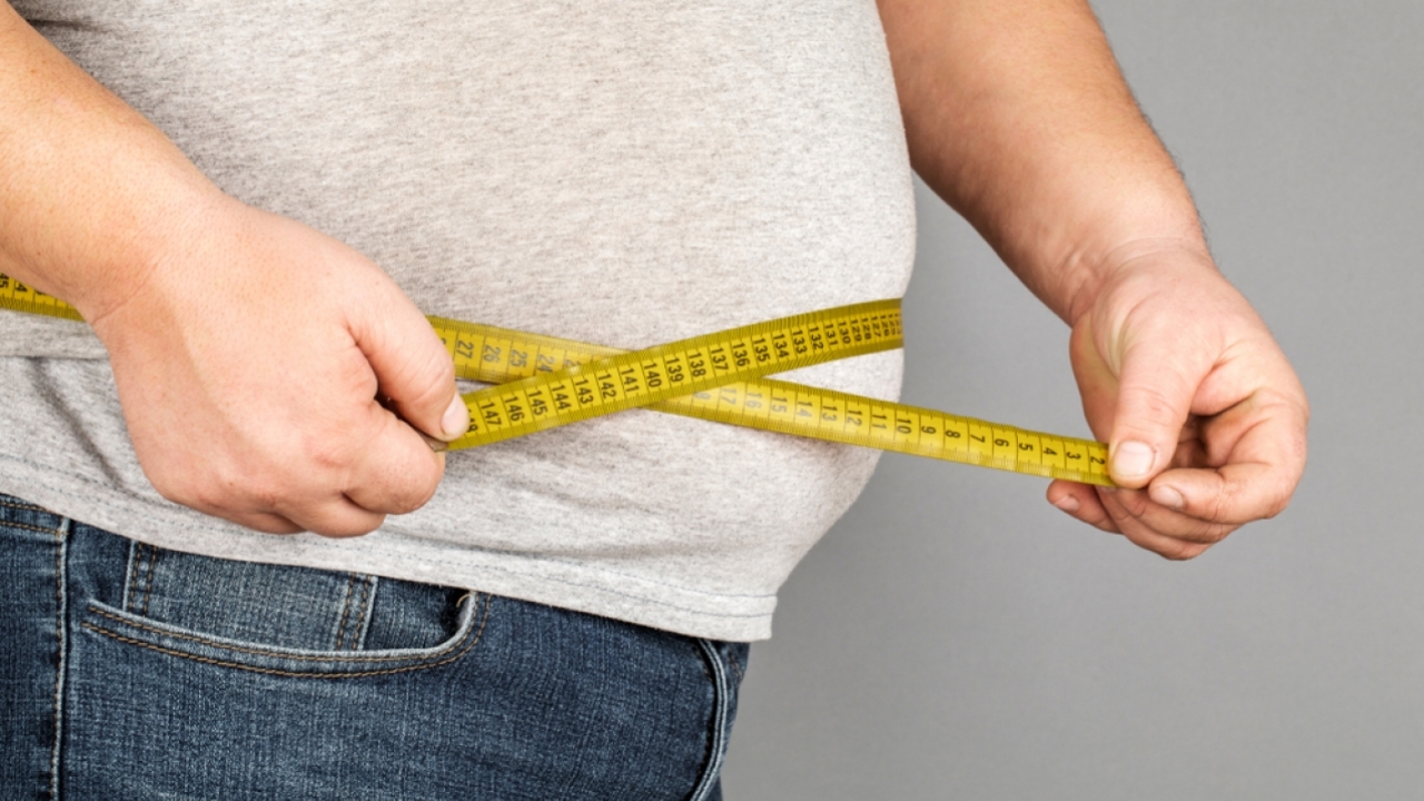 Larger person measures their waist.