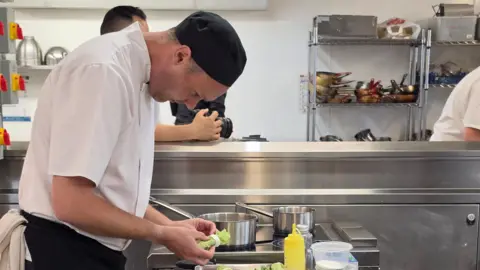 Supplied Richard preparing food in a kitchen.