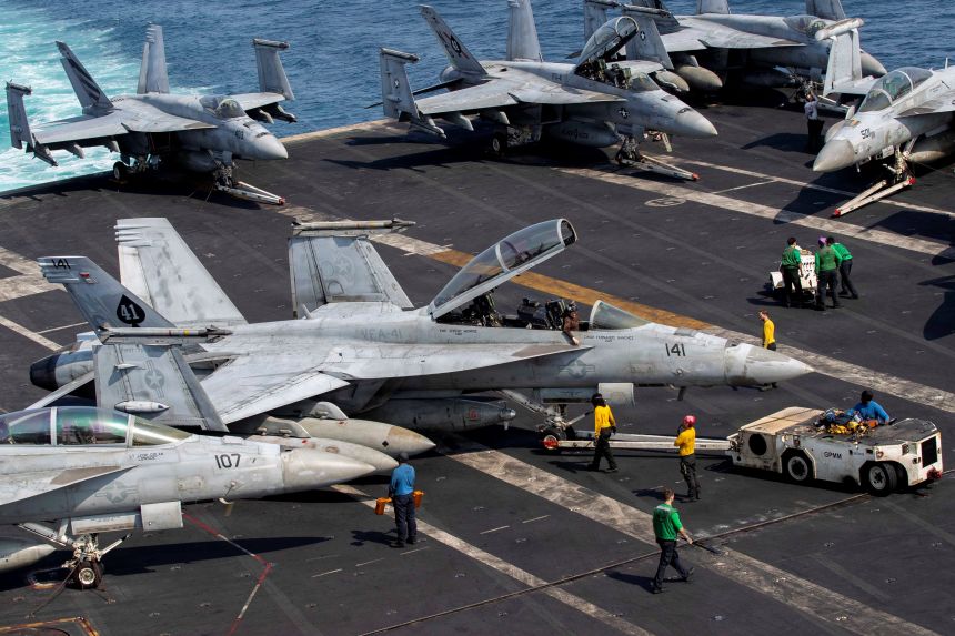 Navy sailors taxi an F/A-18F Super Hornet on the flight deck aboard Nimitz-class aircraft carrier USS Abraham Lincoln in support of the Operation Epic Fury attack on Iran from an undisclosed location on March 17, 2026.