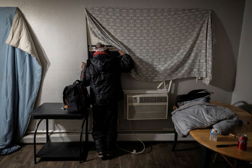 With his bag packed, a Venezuelan man peeks out the window of his apartment looking for any signs of federal agents after hearing reports that U.S. Immigration and Customs Enforcement will be coming to detain immigrants for deportation in Aurora, Colorado, January 30, 2025.