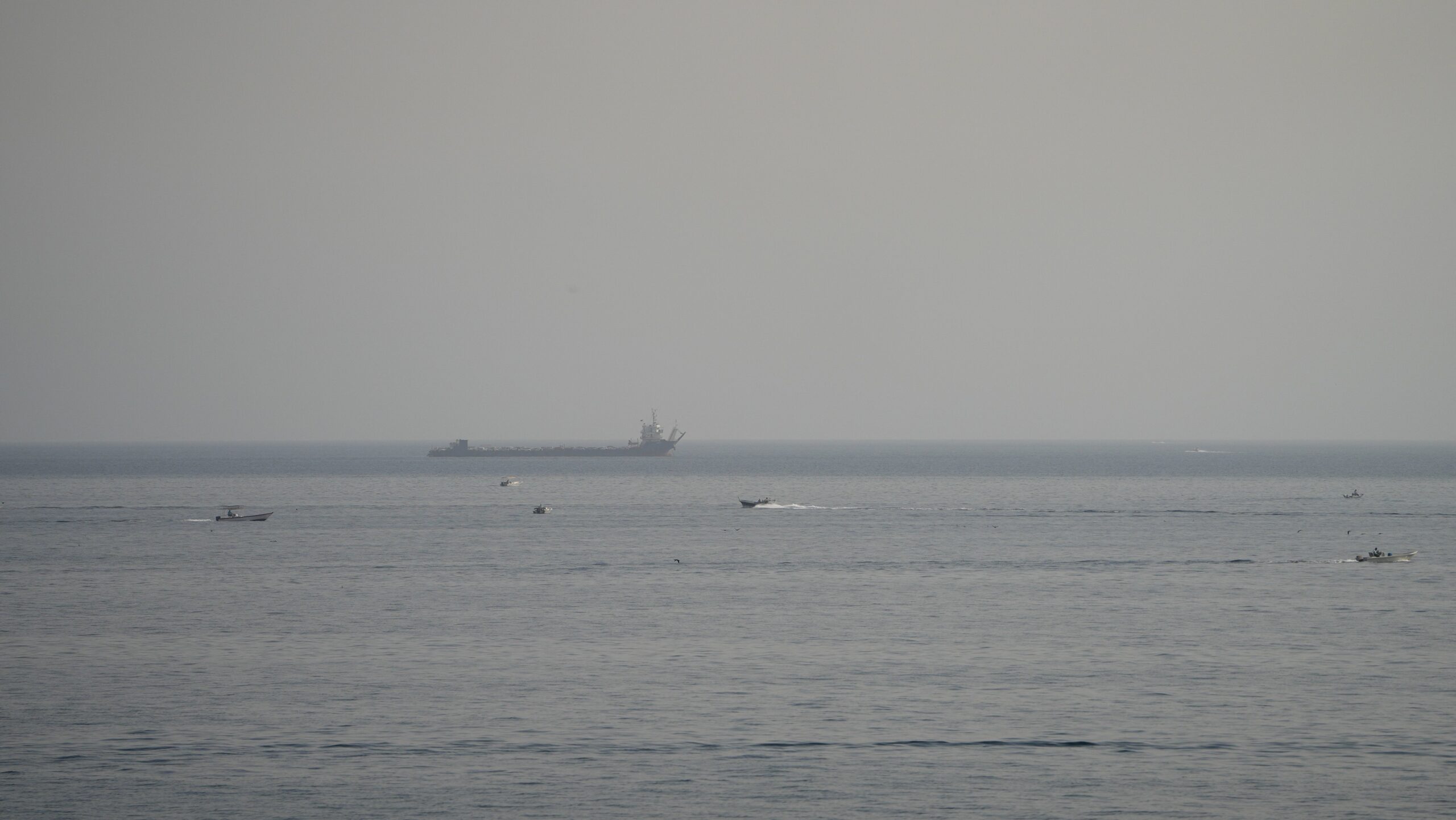 Boats and a vessel in the Strait of Hormuz, as seen from Musandam, Oman, August 3