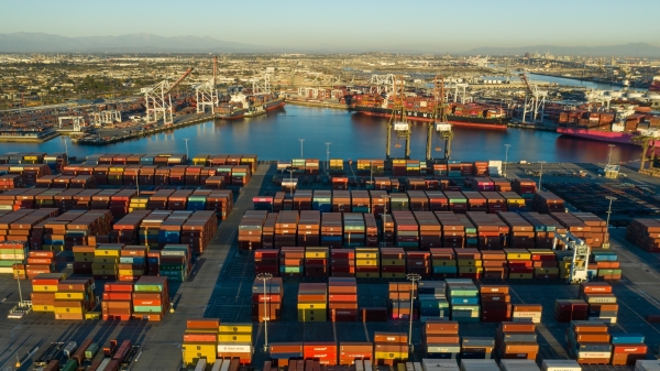 Hundreds of shipping containers sitting in the water at a port.