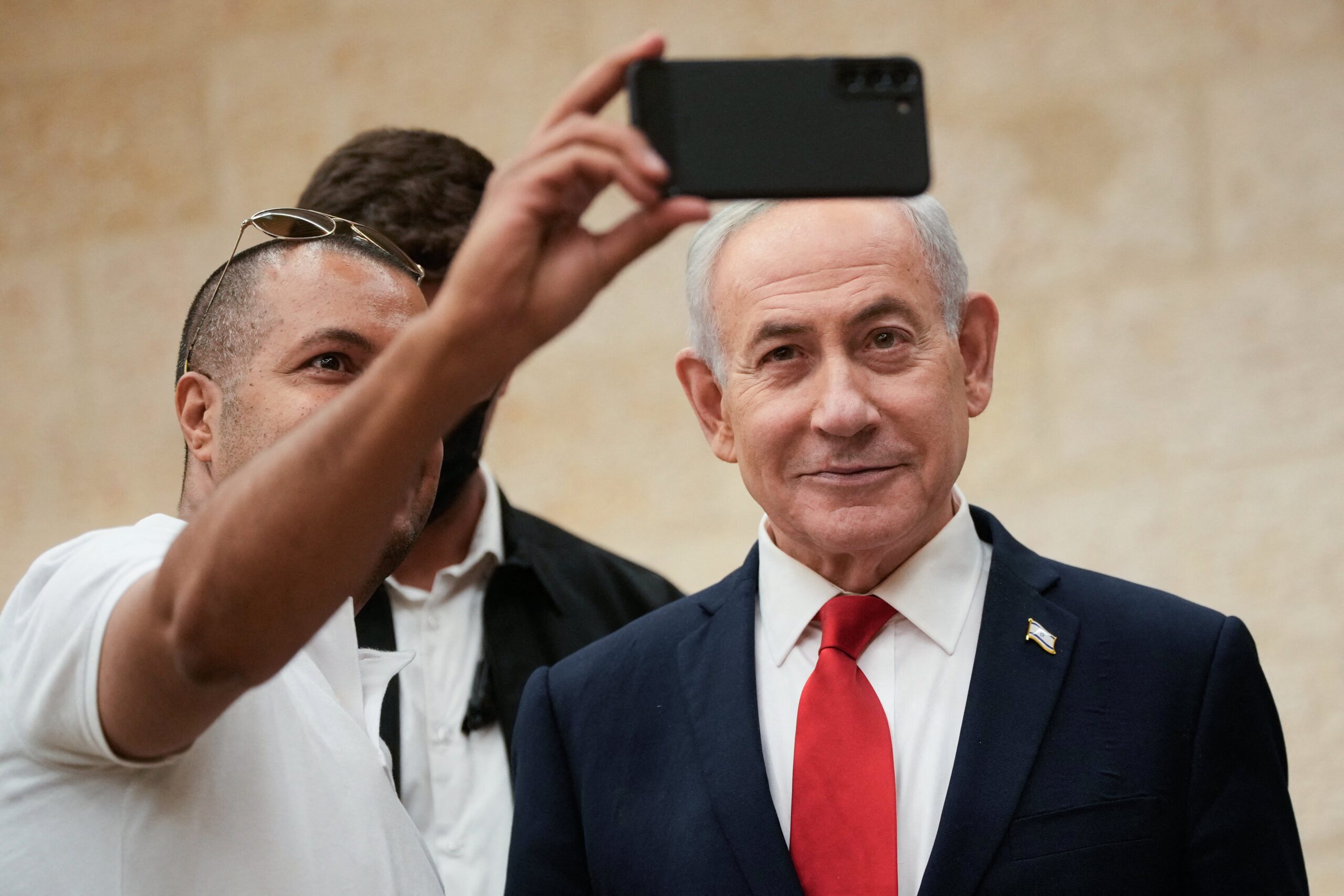 Israeli Prime Minister Benjamin Netanyahu, takes a selfie with a supporter as he arrives to cast his ballot at his party Likud's main polling station during primary elections ahead of Israel's general election in October in Jerusalem on August 17, 2026.