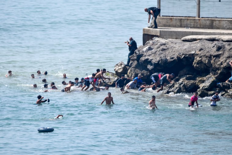 People swim across the border.
