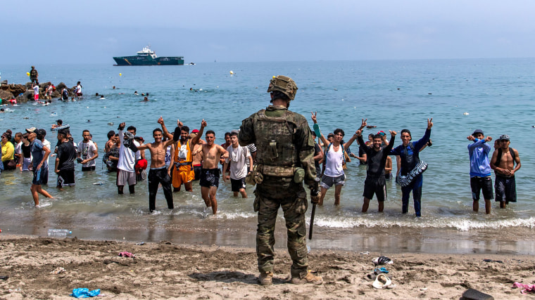 Spanish army soldiers block access to the beach for people crossing from Morocco into the Spanish enclave of Ceuta, Friday, July 31, 2026.