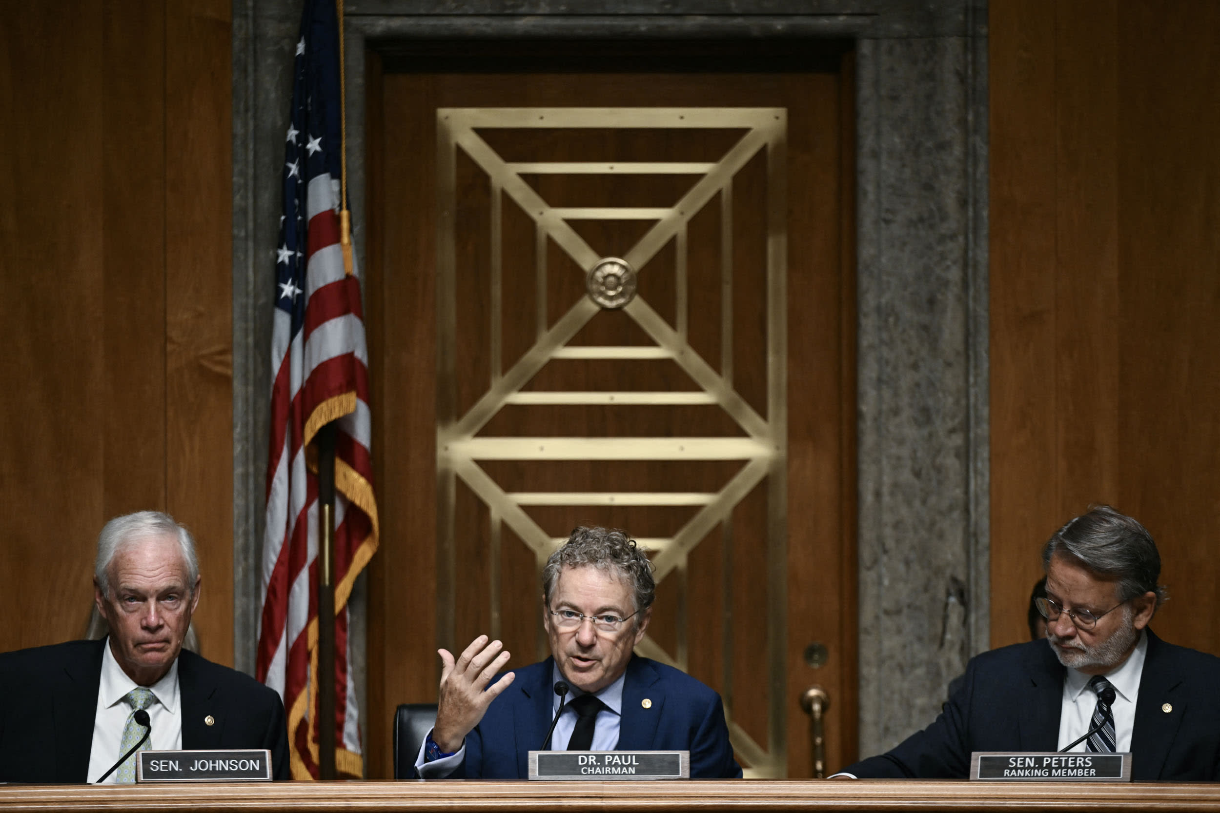 Sen. Rand Paul is flanked by Sens. Ron Johnson, left, and Gary Peters,