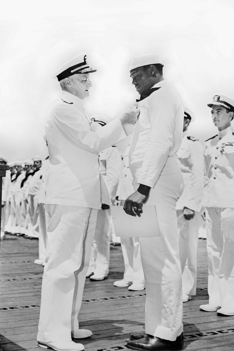 Admiral Chester W. Nimitz pinning Navy Cross on Doris "Dorie" Miller at ceremony.