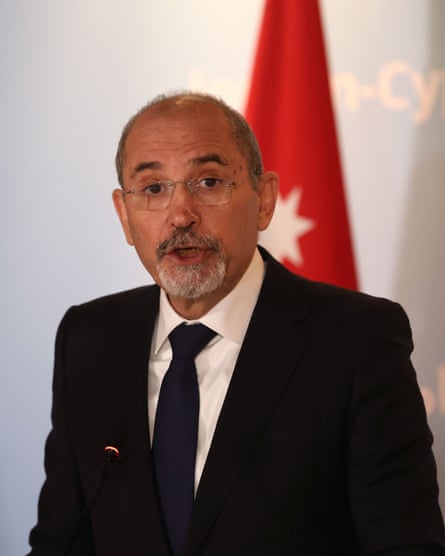 Safadi speaks at a summit. He has a short, neat grey beard and wears glasses. He is in a black jacket with white shirt and black tie.