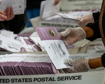 Election workers sort mail-in ballots.