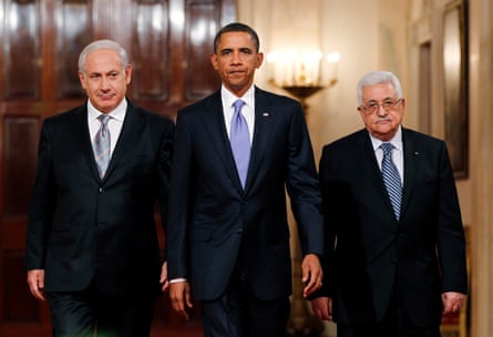 three men in suits walk in a corridor