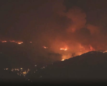 Fires stand out against the night sky across a sweep of mountaintops