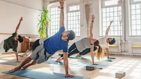 Getty Images Stock image of six people doing pilates in a brightly lit studio