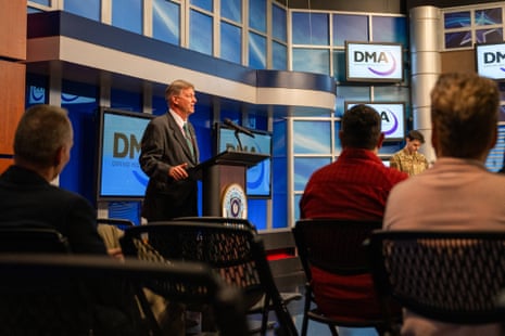 a man speaks into a microphone to an audience