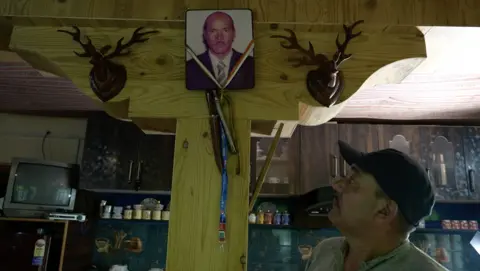 Morup’s eldest son Punchok Dorjai looking at the framed photo of his dad